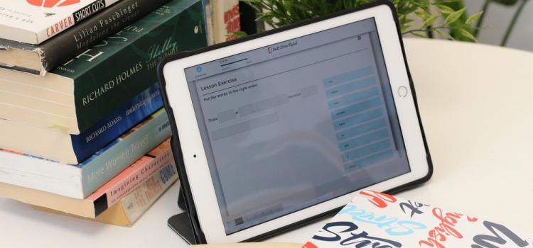 livres empilés et écran tablette qui présente un quiz de la méthode wall street english
